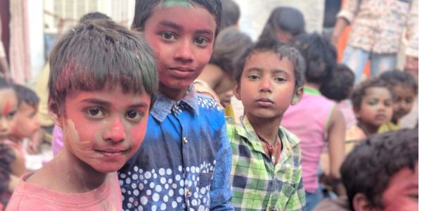 Children with colorful faces at a festive gathering.